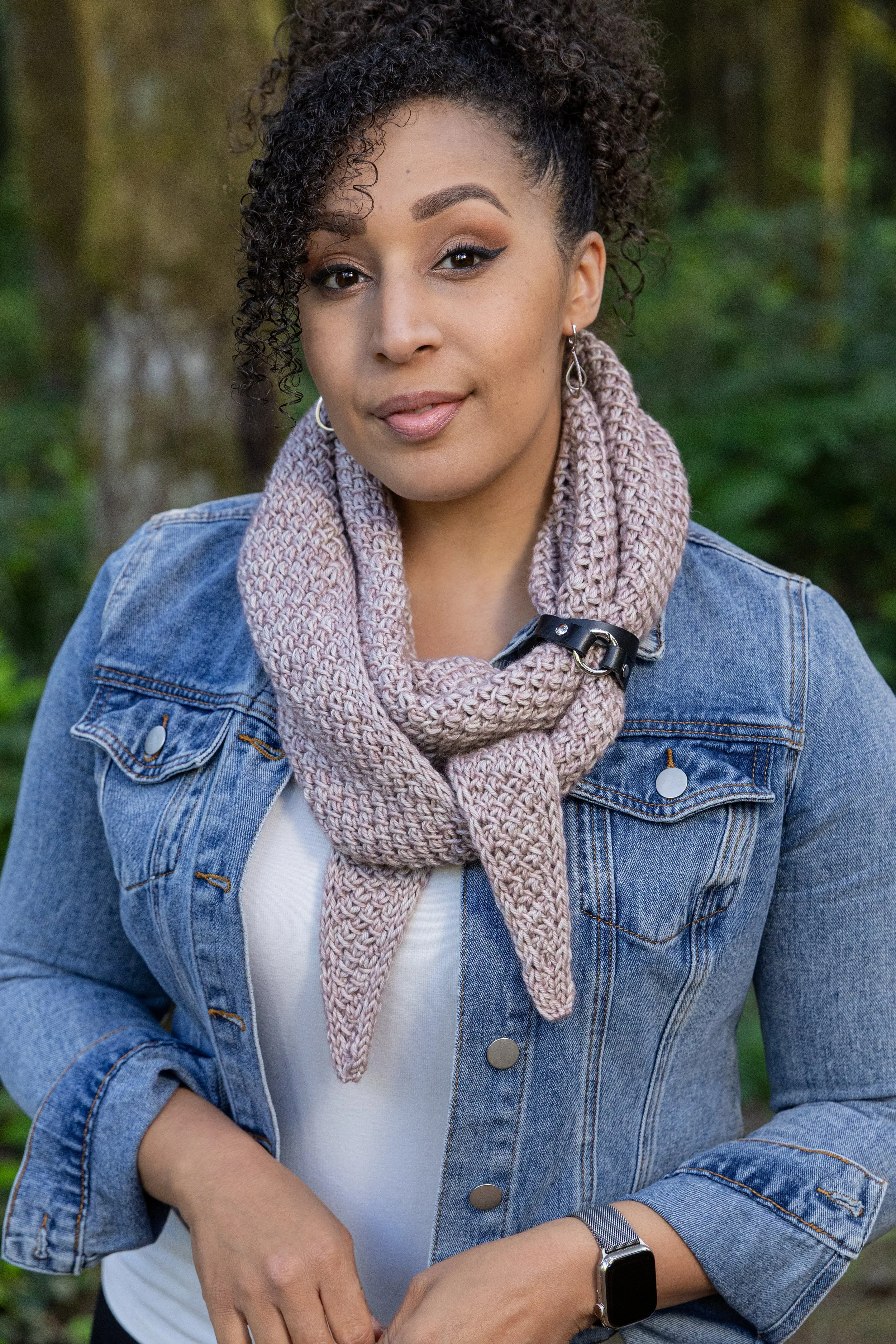 PNW-based knit designer Vanessa Smith wears a beige Tipping Point Scarf styled with a black leather shawl cuff and blue jean jacket. This cozy, triangular shawl starts & ends with just a few stitches.