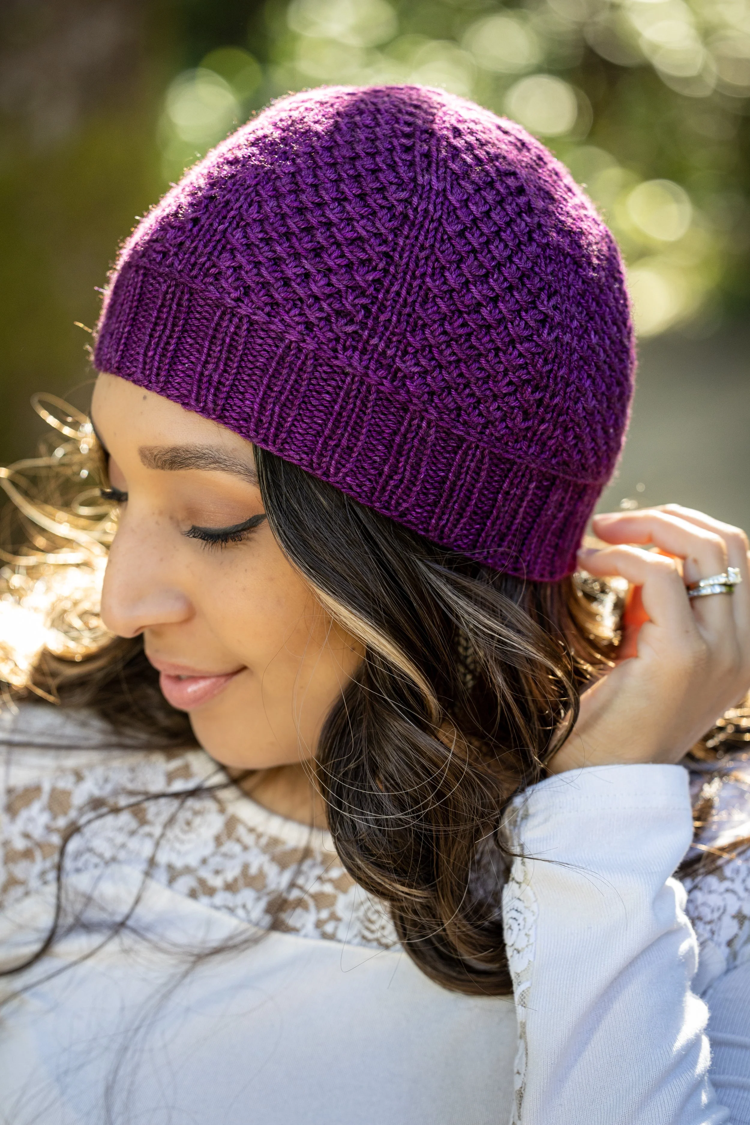 Profilansicht der durchdacht gestalteten Nydia Mütze in dunklem Pflaumenton. PDF-Strickmuster von Vanessa Smith Designs – einfach, strickfreudig und mit zwei Varianten verfügbar.