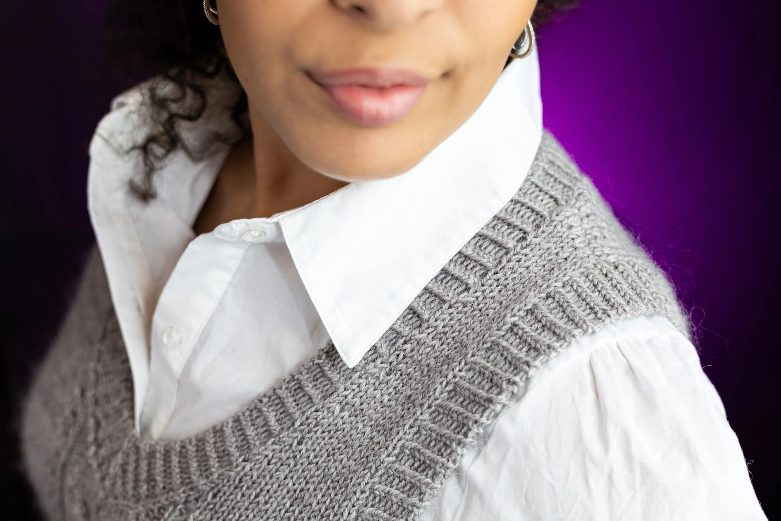 Close-up of the well-defined, twisted rib V-neckline and armhole edging of the Bestie Vestie, a timeless knit vest. Fun, detailed, and clearly written PDF knitting pattern by Vanessa Smith Designs.