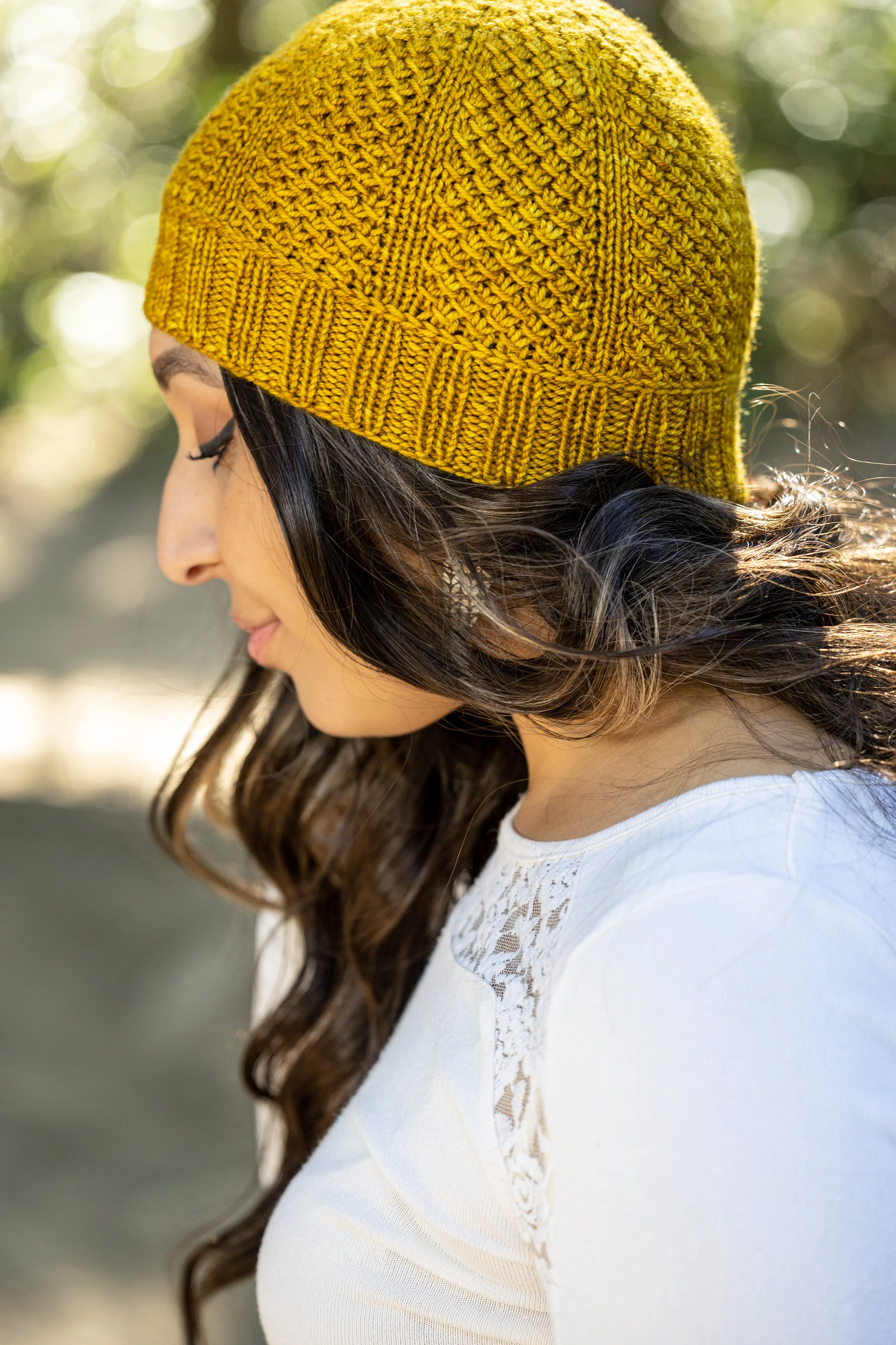 Profilansicht der Nydia Mütze in Tupelo Honey von Magpie Fibers. Die Vikkel Braid trennt das 2x2 Rippbündchen vom leicht zu strickenden Lochmuster – Strickanleitung von Vanessa Smith Designs.