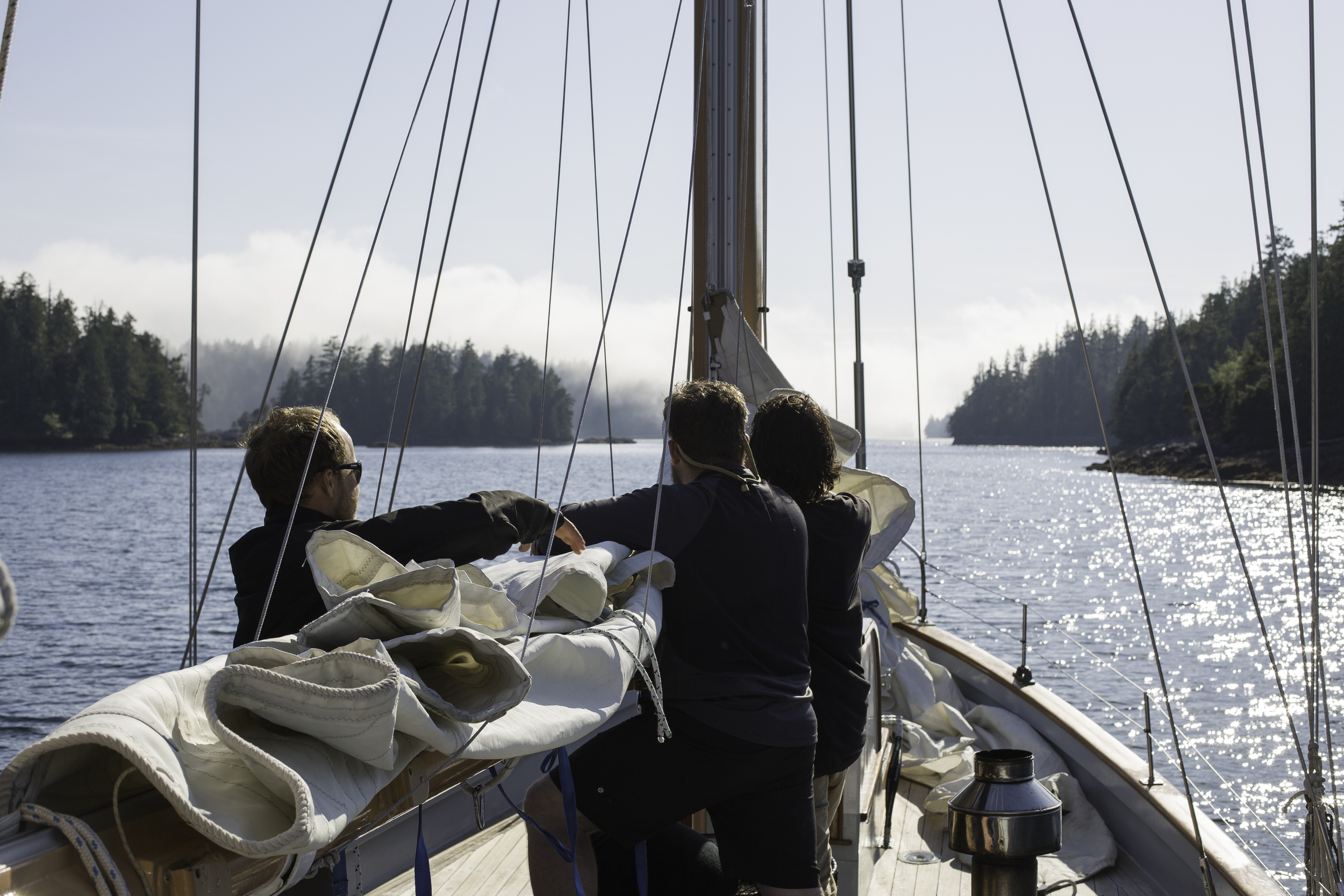 Captain Matt Lemay shows first mates Joel White and Liam Ogel the appropriately named "Burrito Technique" for wrapping up the sails.