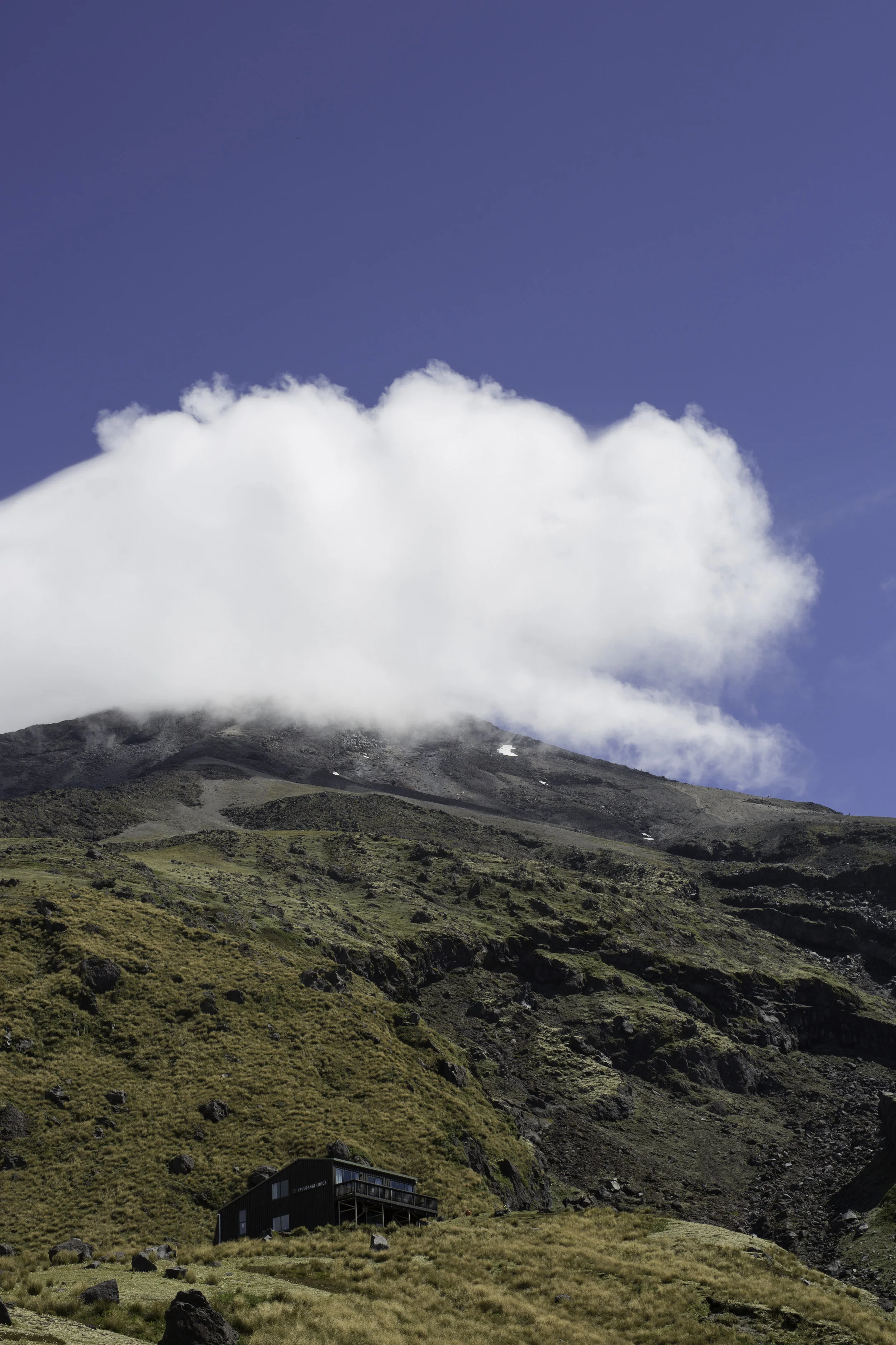The hut mirrors the shape of the perlan clouds pouring over the top of Mt. Taranaki.