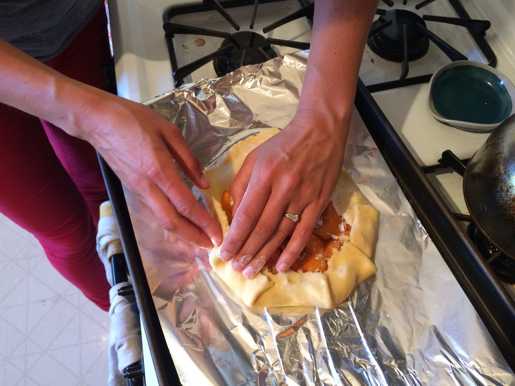 Folding over pastry dough edges.