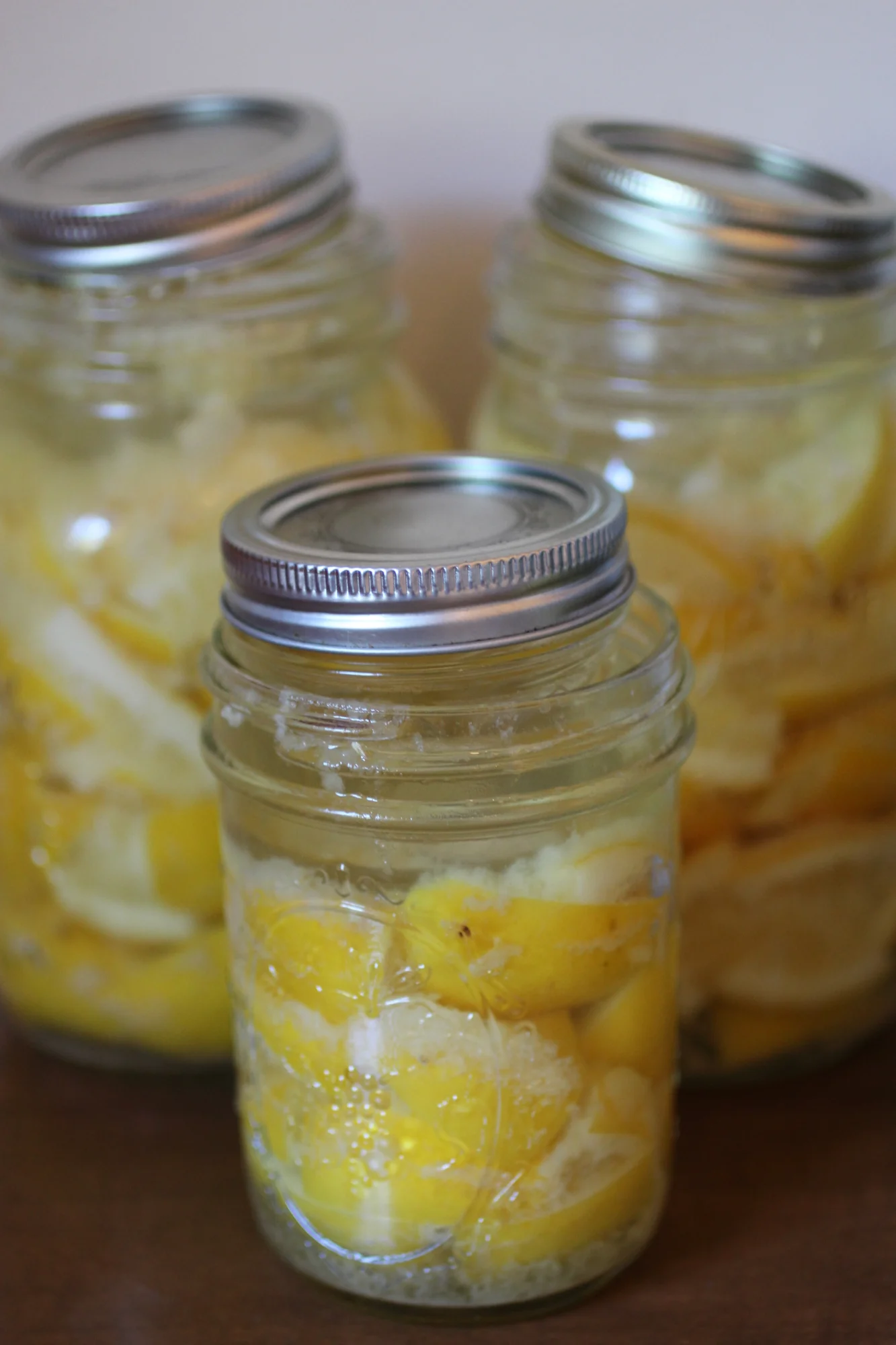 Using smaller (clean) mason jars to help keep lemons under lemony brine.