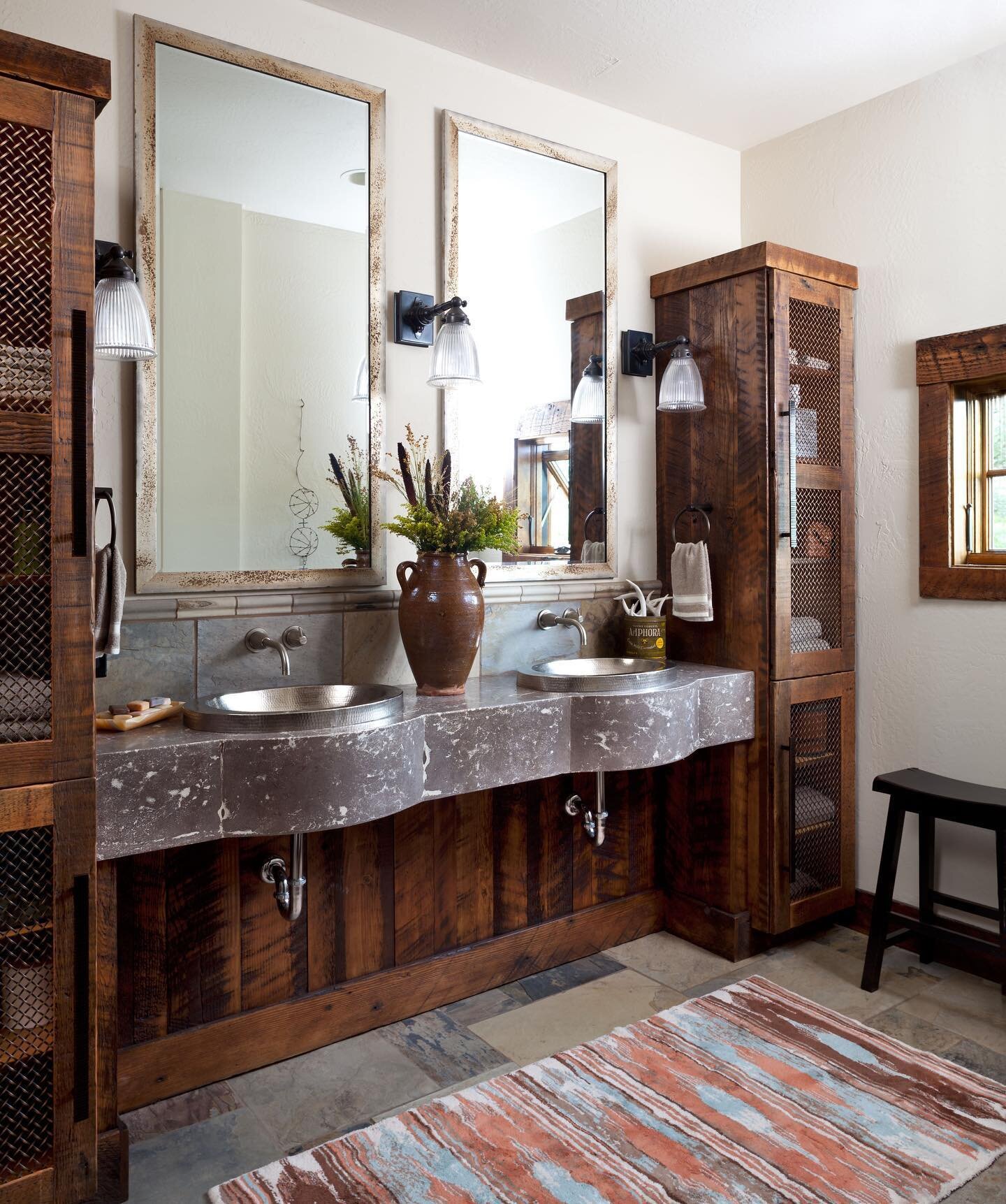 This rustic bathroom is in what we call &ldquo;the exercise barn,&rdquo; where our clients have both their home gym and home office. Look in the left mirror, see something shiny and silver? Nancy and I found a bra made out of barbed wire at the local