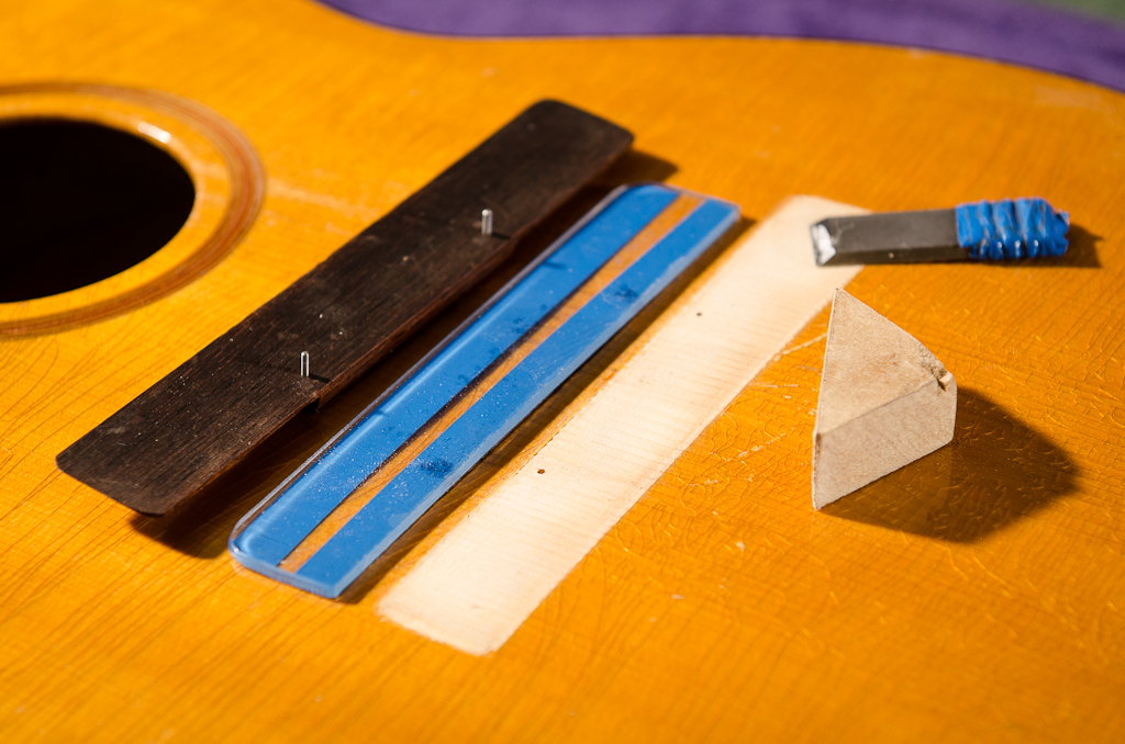 Preparing for reglue: (left to right) bridge with locating pins, scraping/sanding safety guide, scraper and sanding block