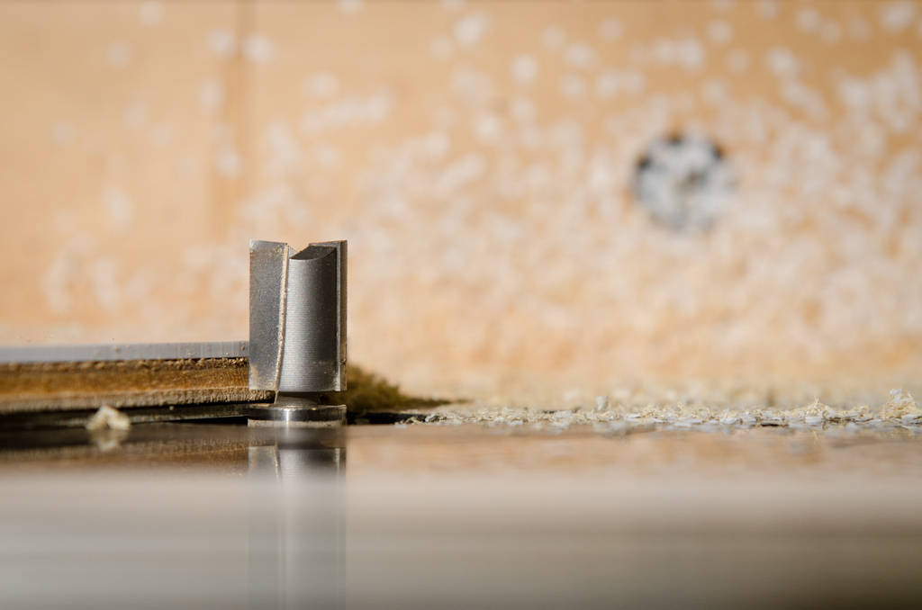 A close up of my router bit. Note the gap between the bearing and the blades of the bit. The original pickguard is on the bottom and rides against the bearing.