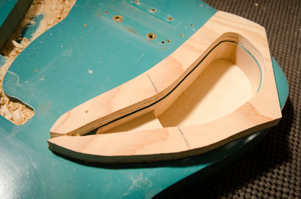 Here is the cavity so far, with some freehand routing to transition down into the deeper main cavity. This maxes out my collar-cutting setup as my bit is not long enough to go to full depth.