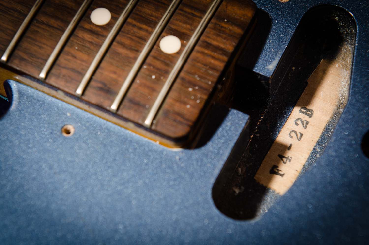 The stock neck pickup is removed, showing the body stamp.