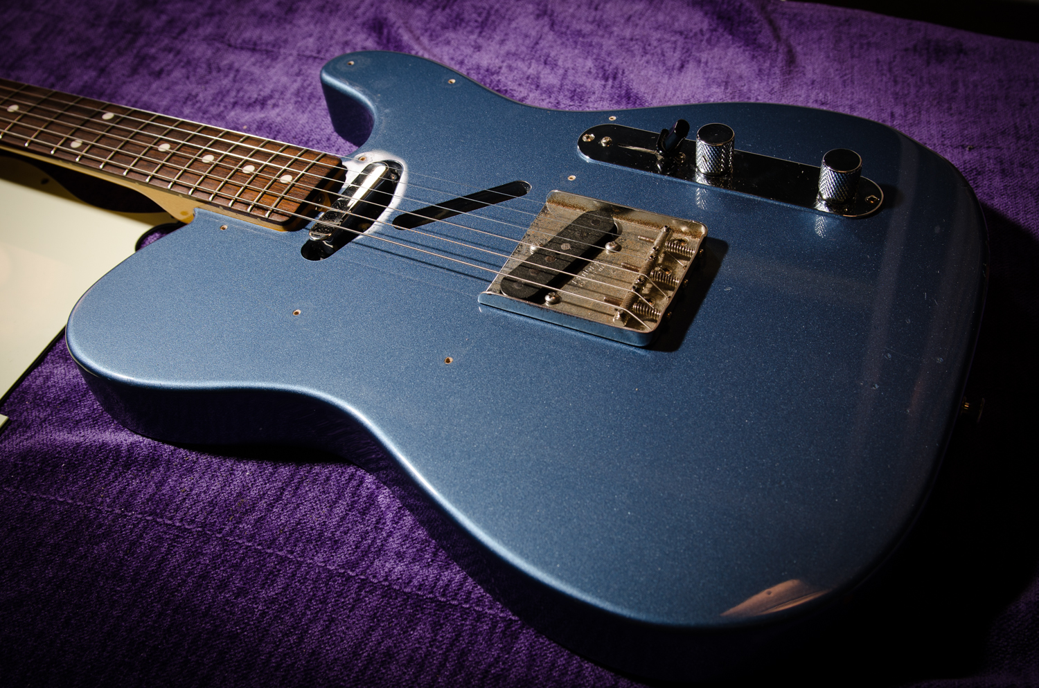 The pickups are installed and the guitar is restrung. The pickguard is left off so that the neck pickup height can be adjusted relative to the strings and balanced with the bridge pickup. The guard goes on after those adjustments are set with no need to loosen the strings.