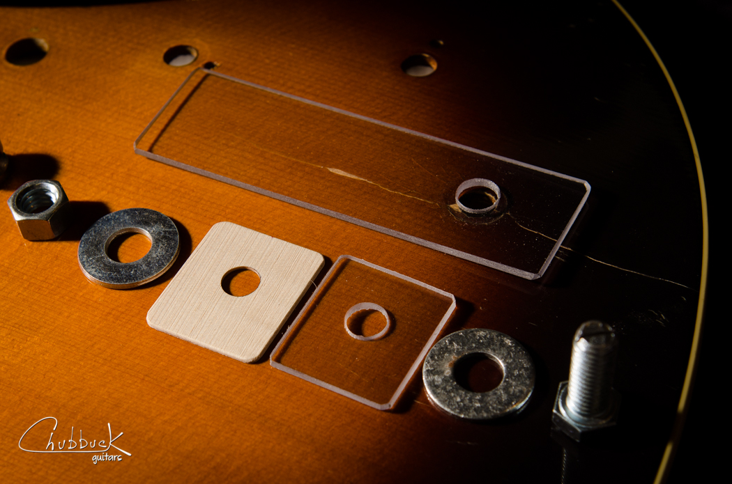Here is the breakdown of the clamping setup. It assembles from right to left. Bolt, washer, small plexiglass and maple reinforcement go inside the guitar. Large plexiglass, washer and nut go on the outside.