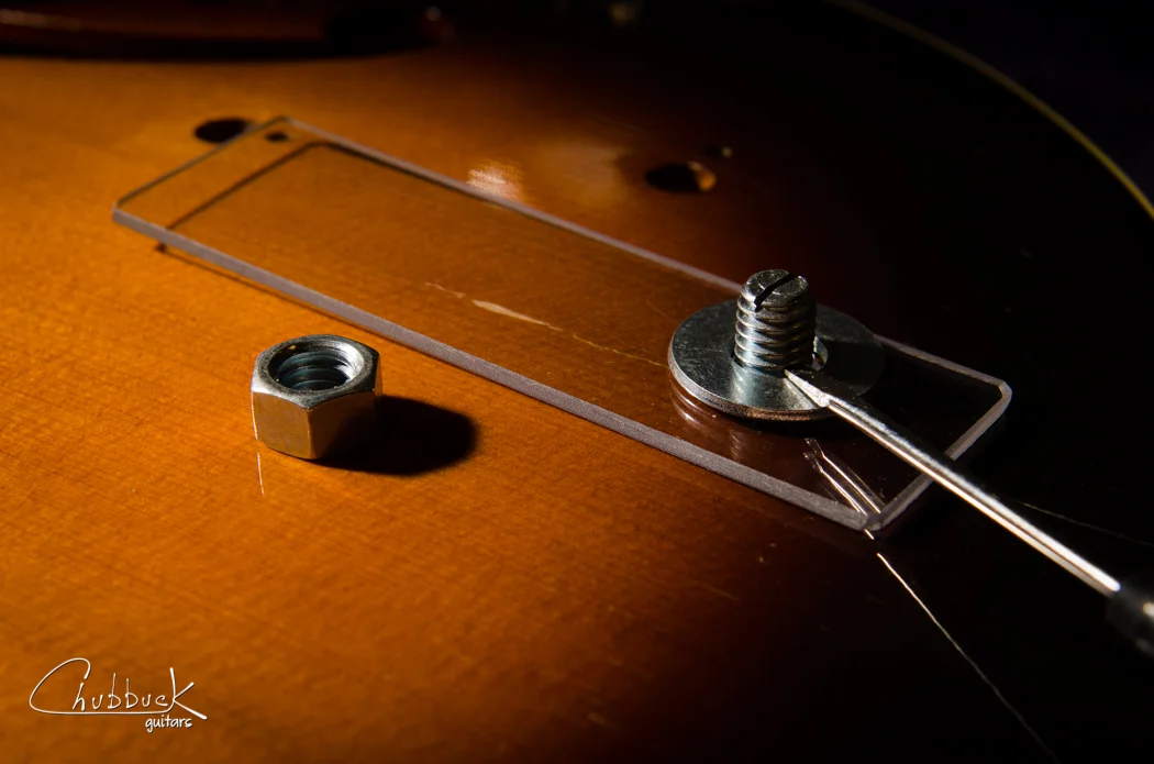 With the magnet stack removed, make sure that the bolt does not fall back into the guitar or you will have to start over! I used the slotted screwdriver to hold the bolt in position while I assembled the exterior caul and washer. Once you get the nut started onto the bolt threads you are out of the woods.