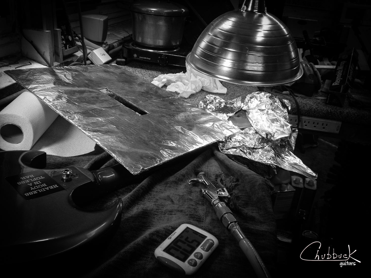 The break was only partially open. I needed to apply heat and steam to re-break the headstock. An ifrared heat lamp bulb was used for dry heat and in the background is my neck-reseting pressure pot rig that I used to apply hot steam to the joint. 