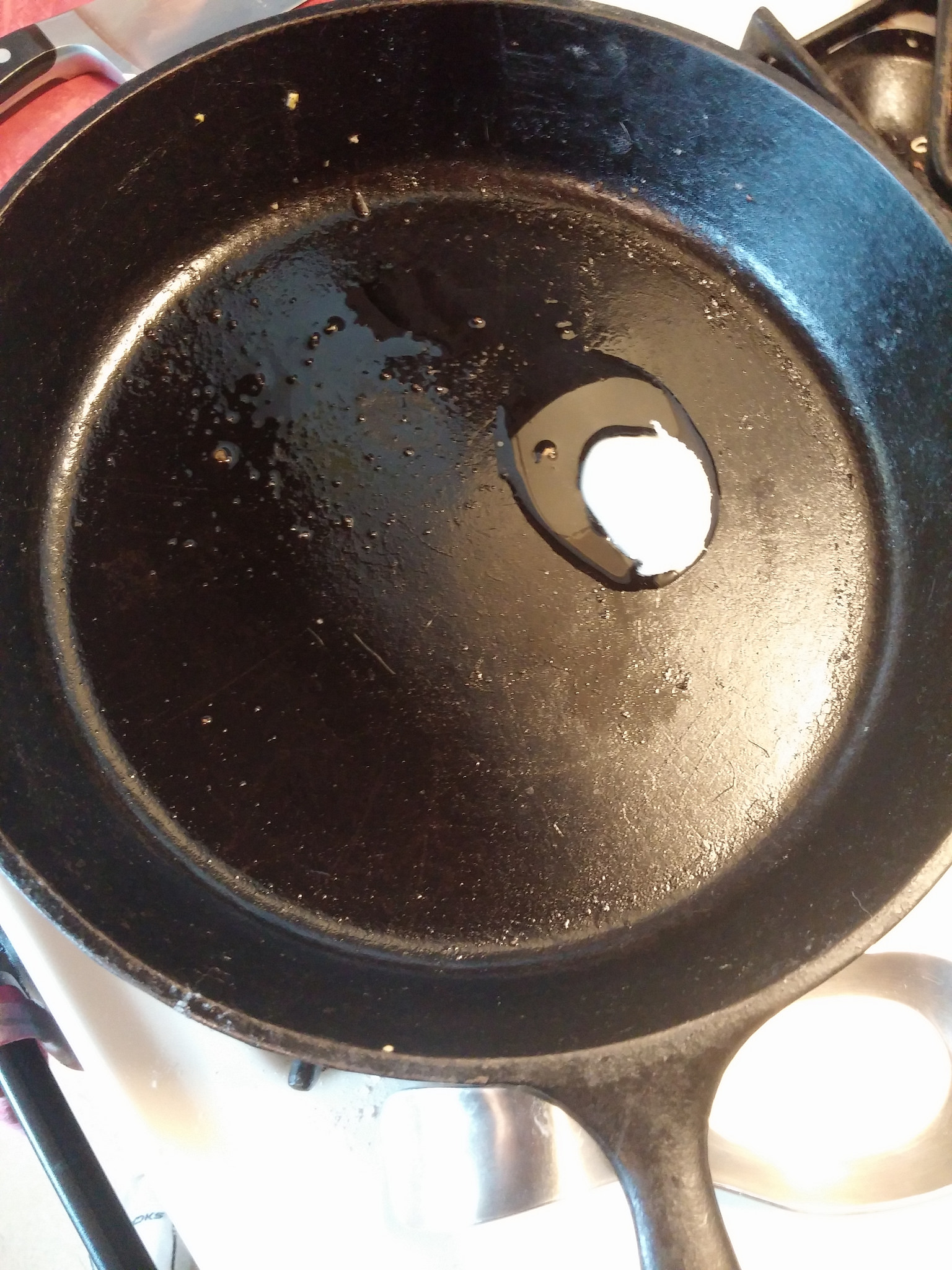 Yes, I reuse the cast iron skillet without cleaning it out all that well. No, it hasn't killed me yet. 