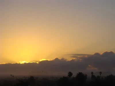 First glimmer of sunrise from behind the rain clouds in Santa Monica, We can't solve problems by using the same kind of thinking we used when we created them. …Albert Einstein
