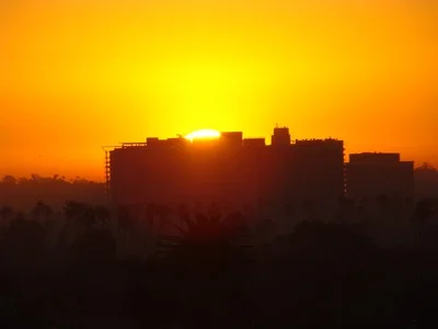 Sunrise leaps up from behind the big building in Marina del Rey from Santa Monica. There are only two ways to live your life. One as though nothing is a miracle. The other is as though everything is a miracle. …. Albert Einstein