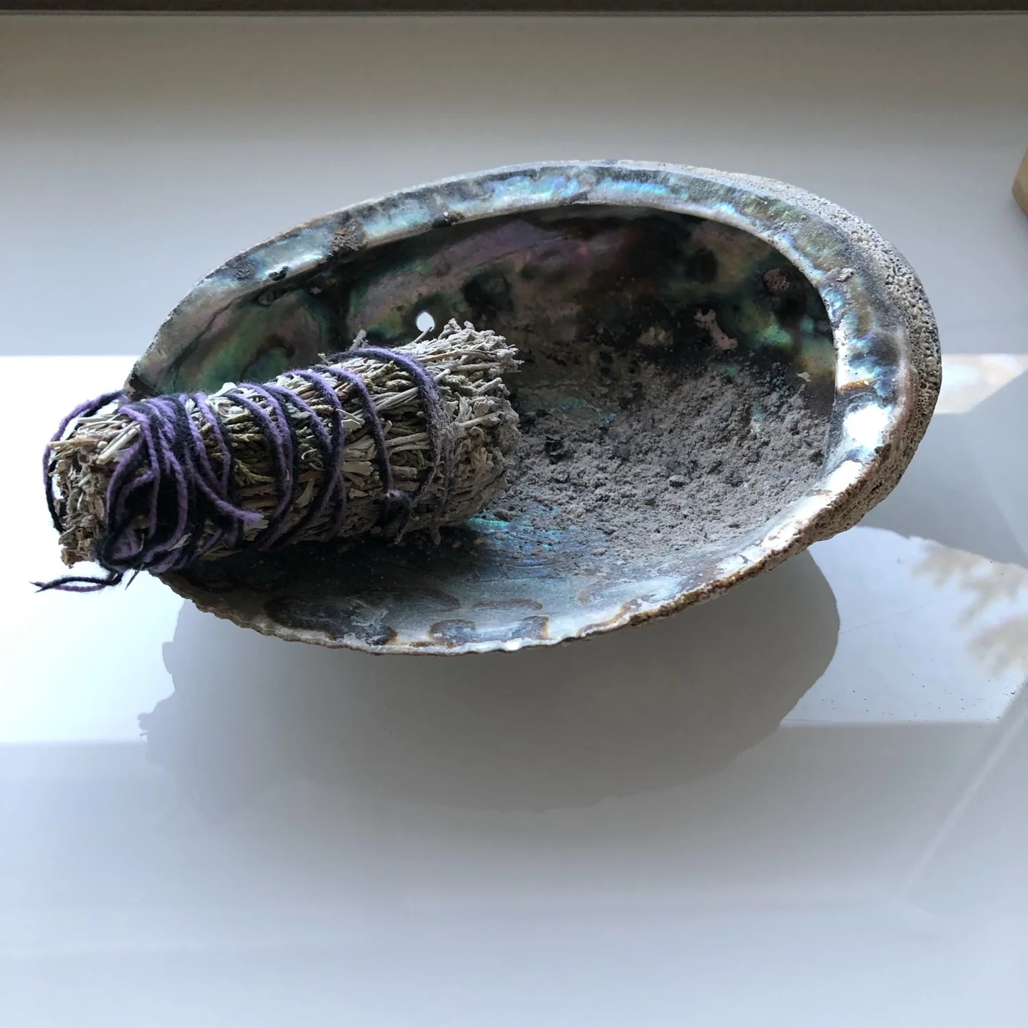 Our bundle of white sage, and the abalone shell that we use to catch the ashes while we walk throughout the house.