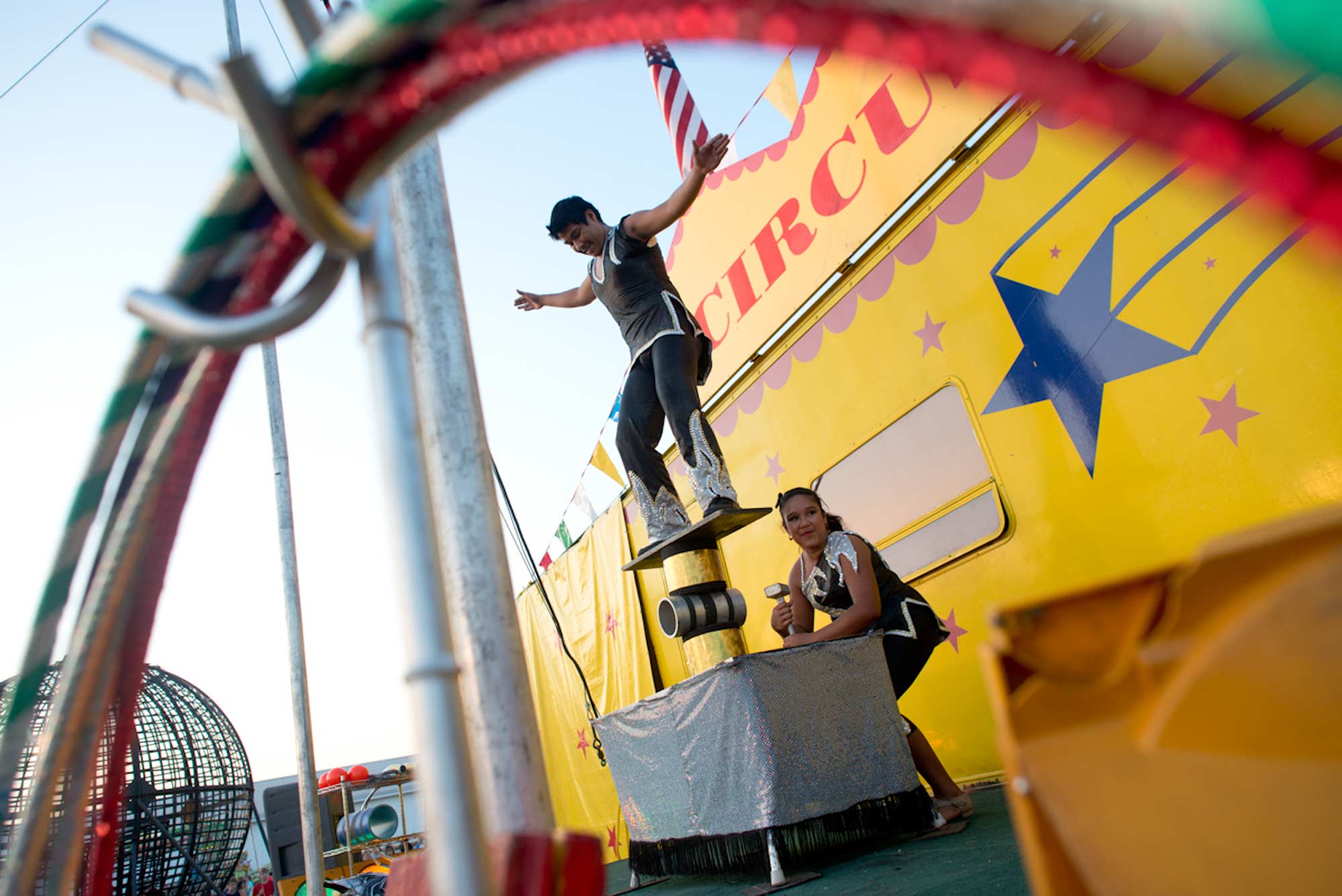 Romario balances on the Rola Bola while Belgica removes his step. The siblings were born into the circus, just like the rest of the performers, and it is the only life they've known.
