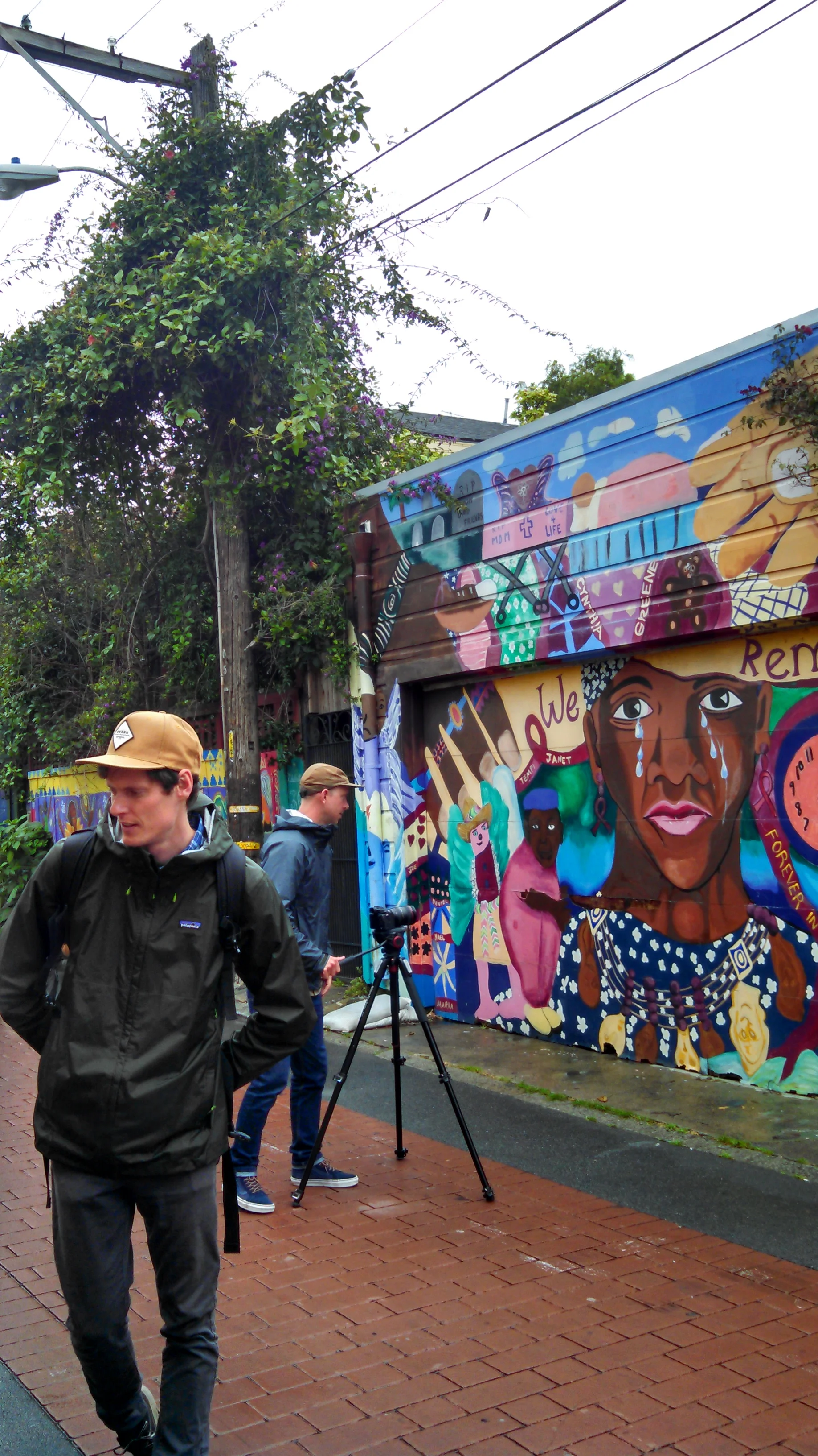 Plus M Productions filming in Legal Services For Children's mural in Balmy Alley.