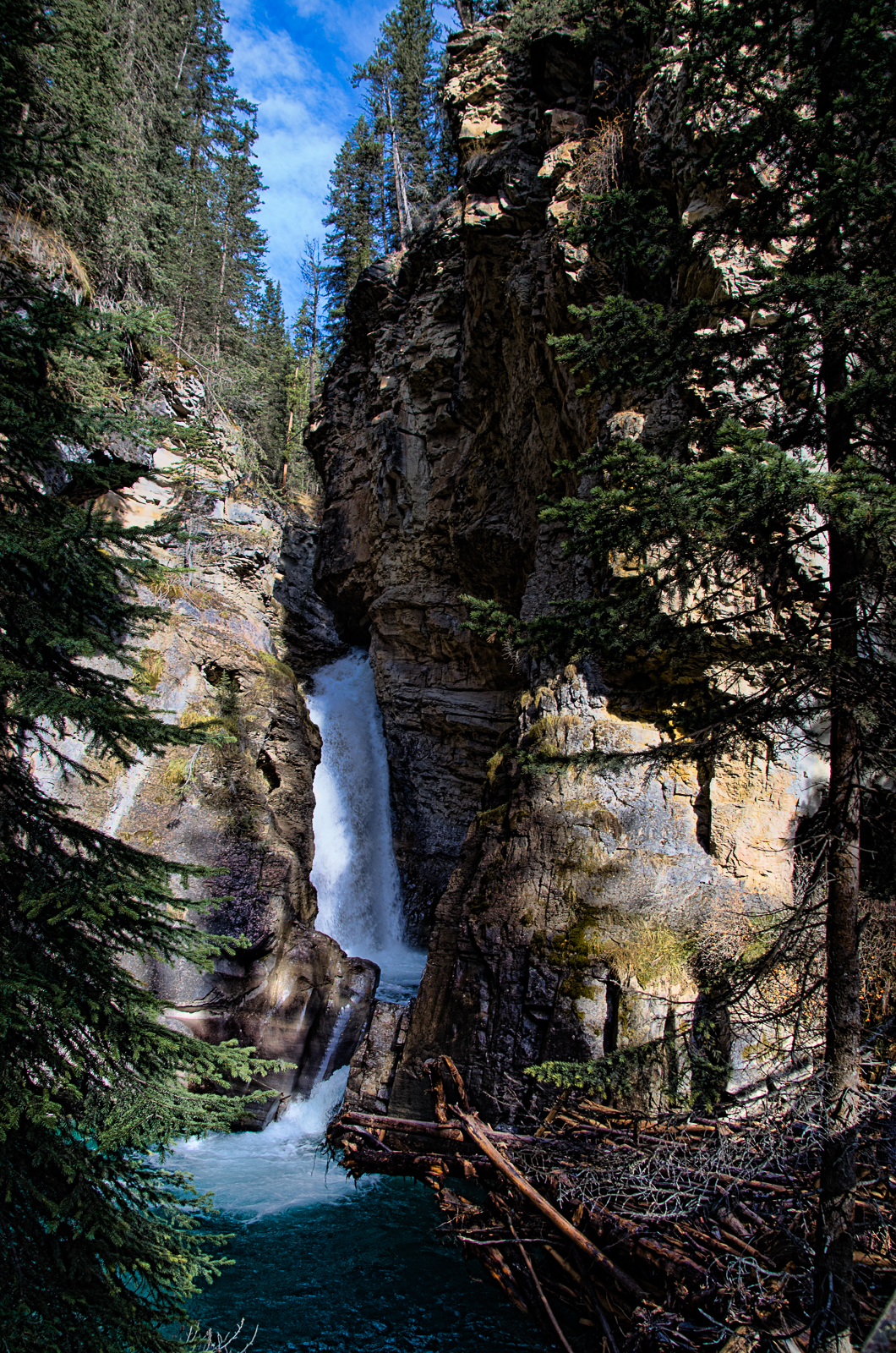 Falling Through The Canyon. Johnston Canyon is located in Banff National Park, Alberta, Canada. This was such a neat area to walk through. This is the lower falls, which is still a nice little hike to get to. Maybe next time we will keep on hiking to the next falls.