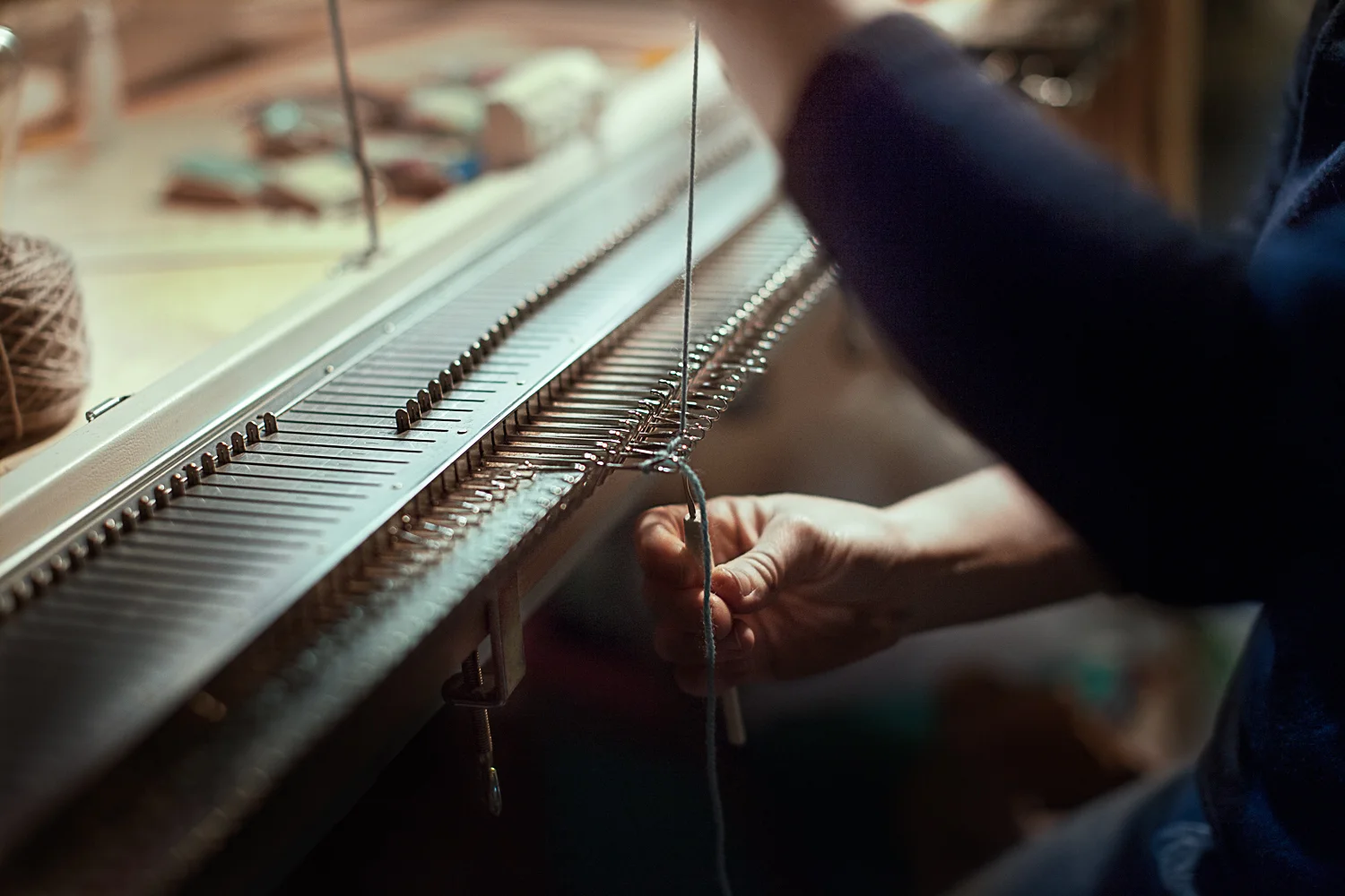 image of hands weaving on a loom