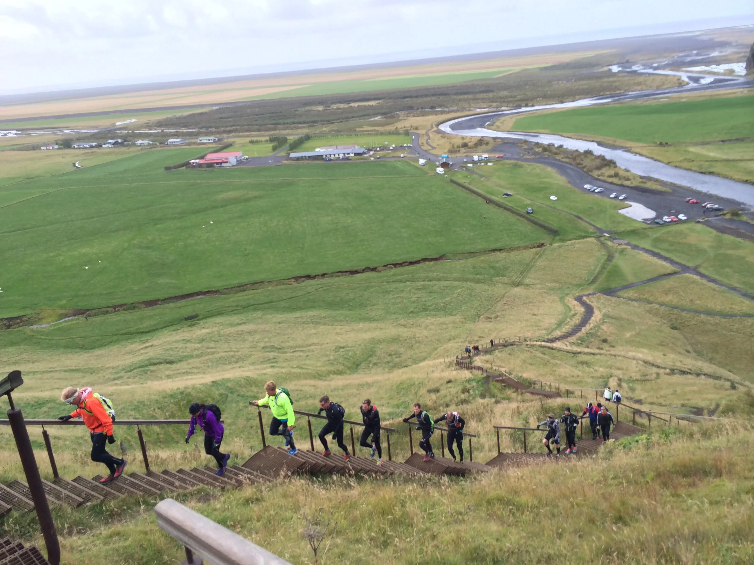 Running group running uphill along Skógafoss