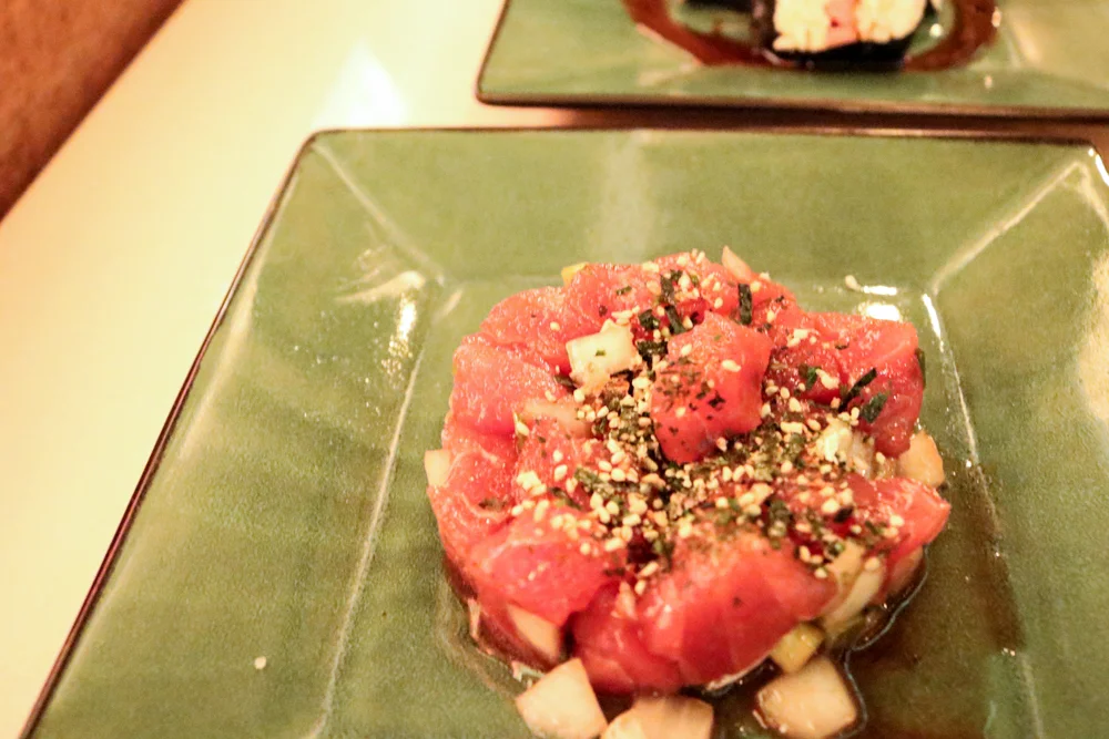 Poke, Ahi tuna with white onions seaweed green onions and sesame seeds
