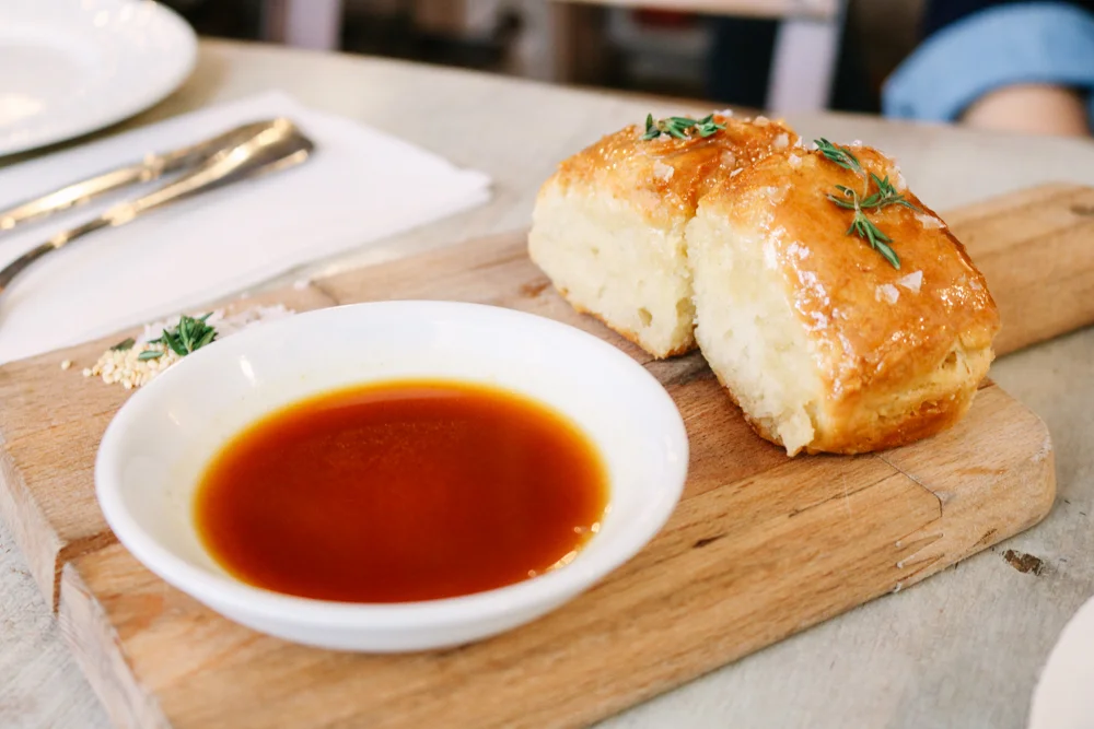 Grandma Daisy's Angel Biscuits, NY honey roasted chicken jus, fresh thyme, toasted benne seeds & sea salt