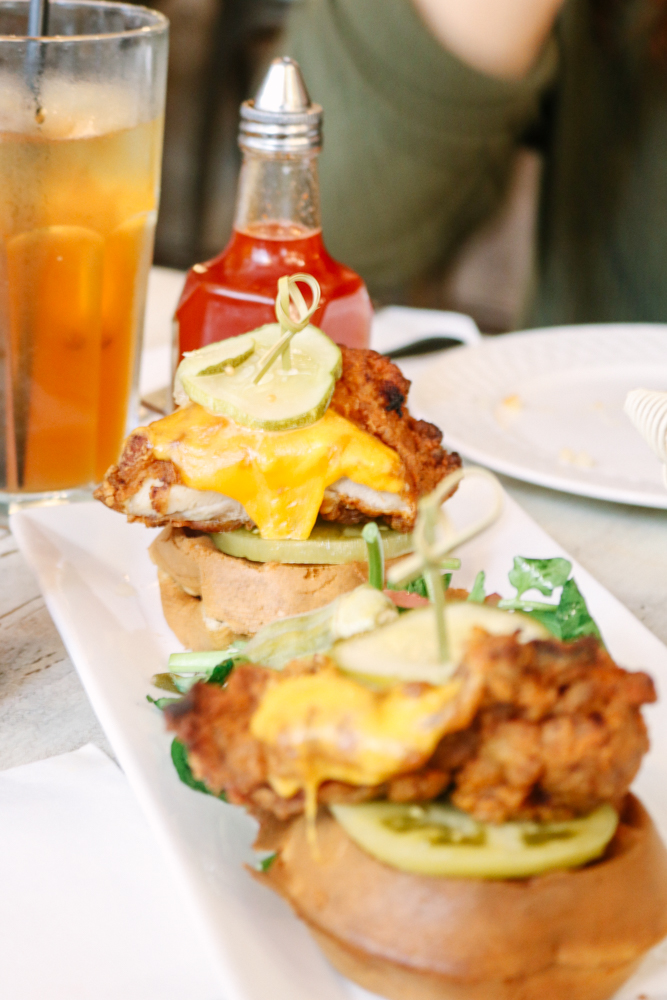 Fried Chicken & Waffle Sandwich, pickled green tomato, baby kale on a waffle with cheddar