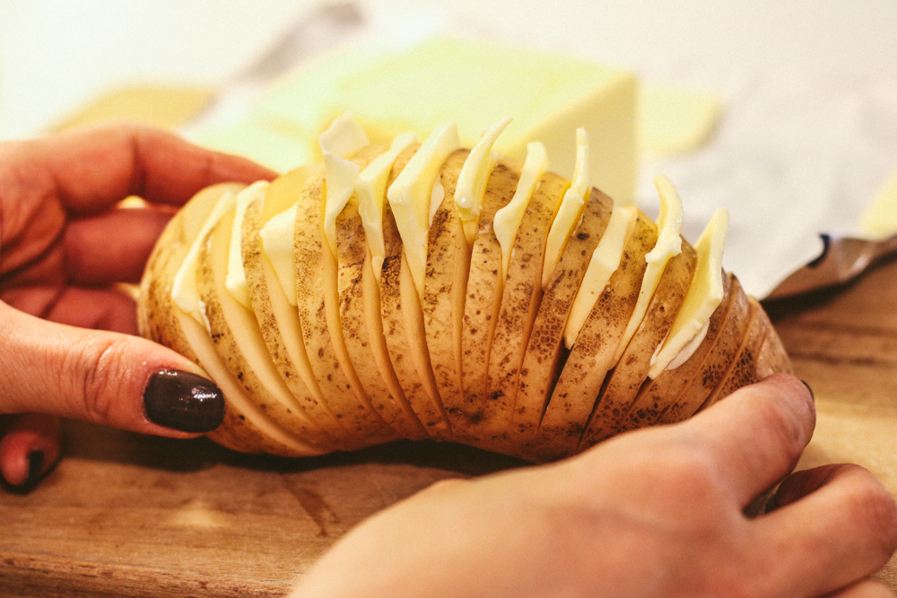 Place thinly sliced unsalted butter blocks in between potato cuts