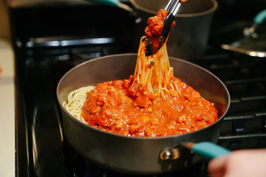 Add well-cooked Spaghetti noodles into the Sauce Pot, and mix them well together.
