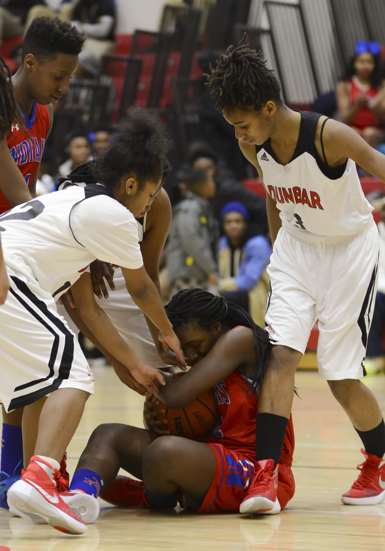 Kirby Walker (24), of Anacostia High School, shields the basketball against players from the Dunbar High School team in their game on Jan. 13, 2014 in Washington D.C.