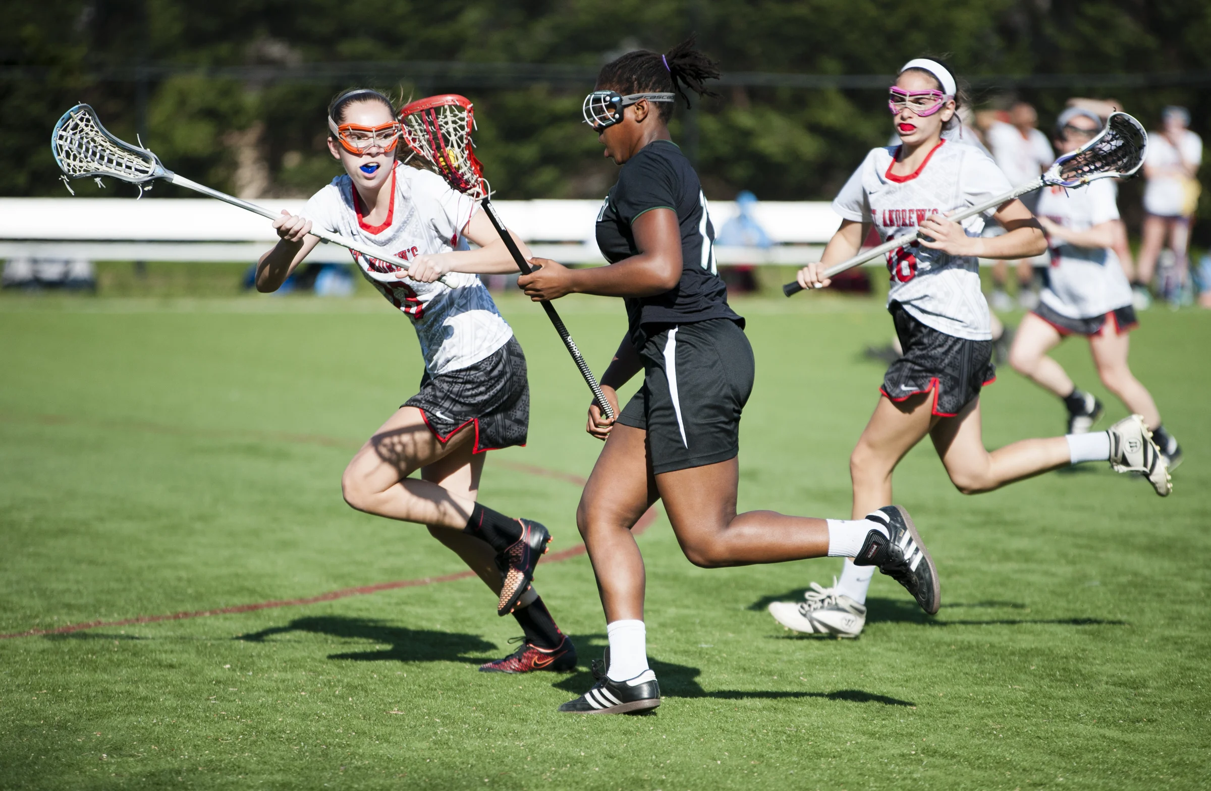 Midfielder Caroline Simpson of St. Andrews Episcopal School attempts to stop an attack on goal from the Maret School lacrosse player (11) on April 14, 2016 in Potomac, MD. St. Andrews Episcopal School beat Maret School 20-8.