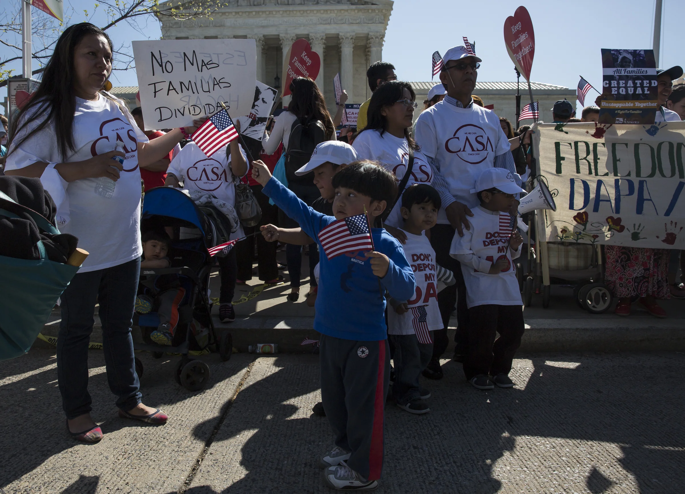 A boy waves his American flag as his family stands in front of the Supreme Court to support DAPA and DACA on April 18, 2016.