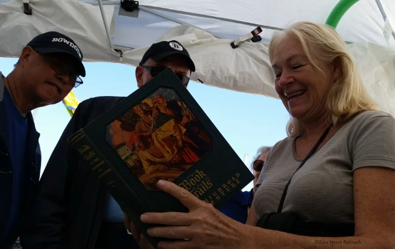 Visitors to my Fresh Paint festival booth examine a book I altered before their eyes.