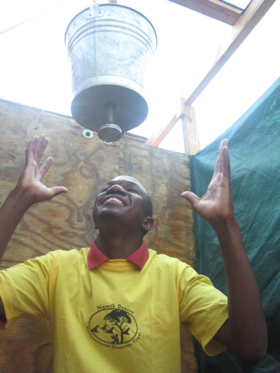 A staff member models the bucket showers