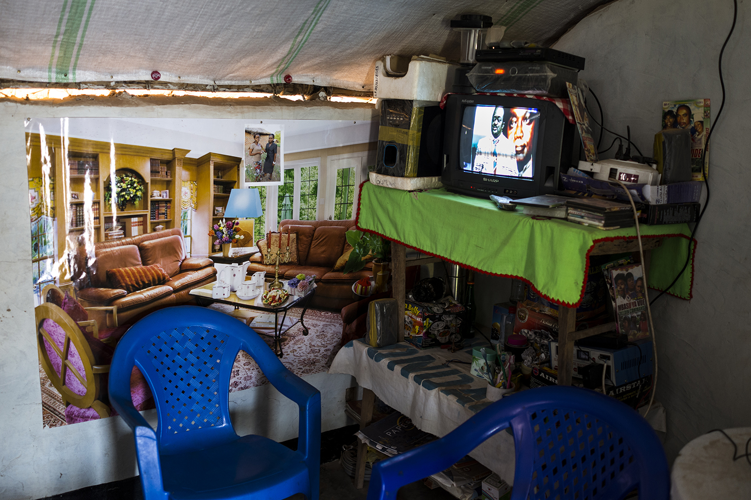  A poster of a living room inside the living room of a mud hut. 