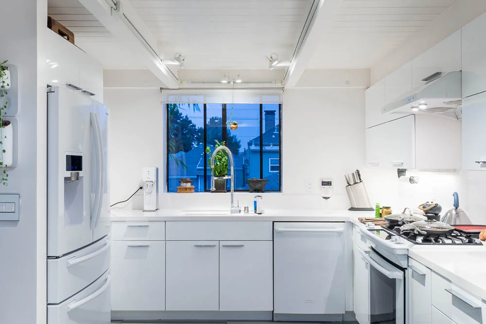 Kitchen at night, with 4 door refrigerator, dishwasher, range