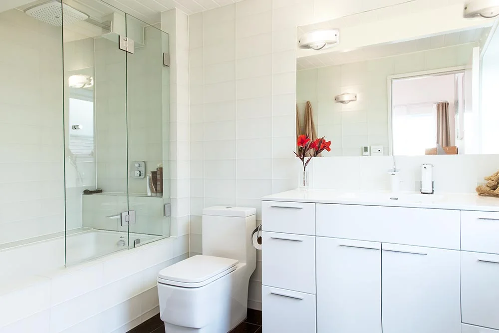 Master bathroom with frosted glass tiles on walls, large tub, rain shower, heated floor