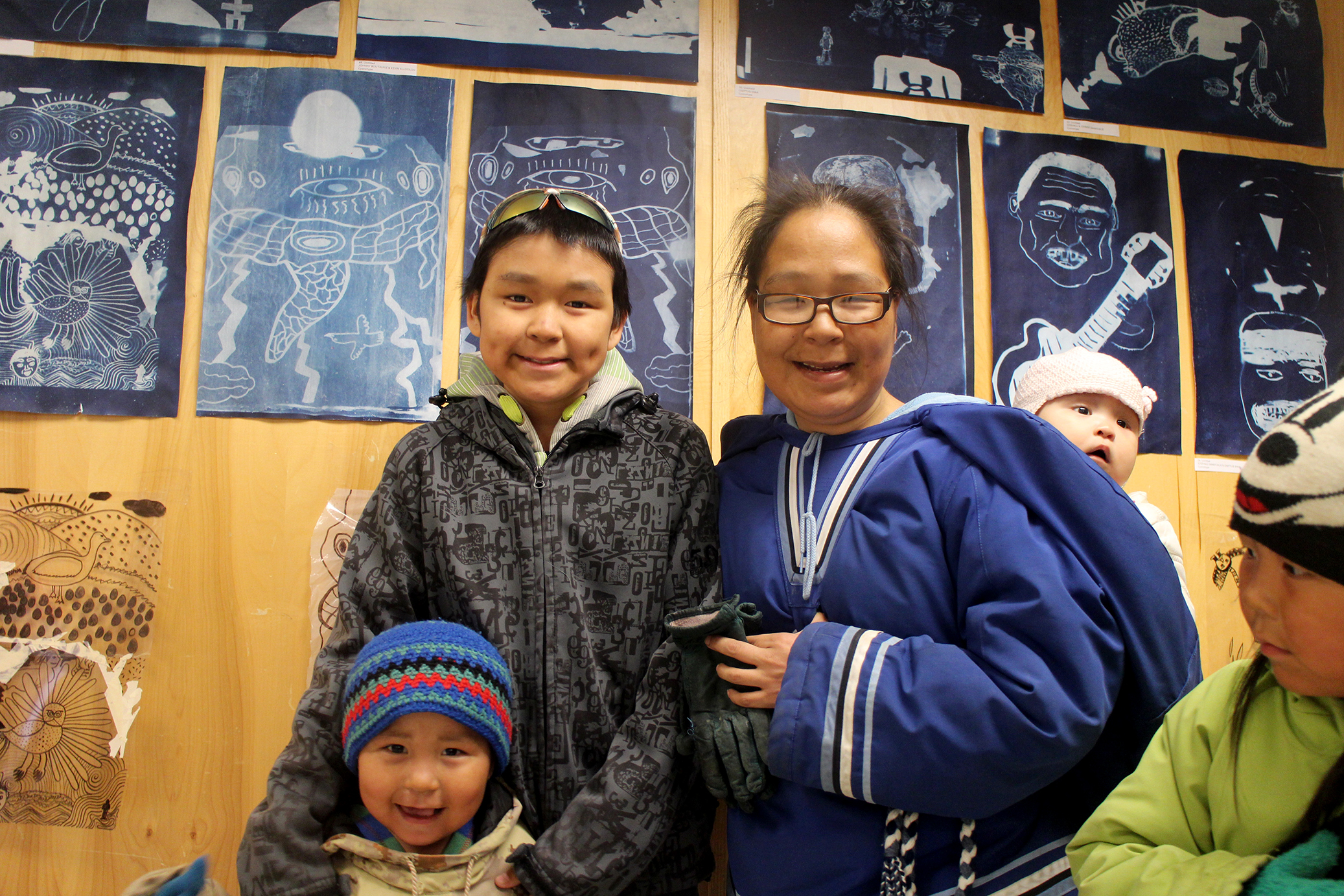 Tommy Quvianaqtuliaq and his family in front of his cyanotype prints (lightning and eyes!)