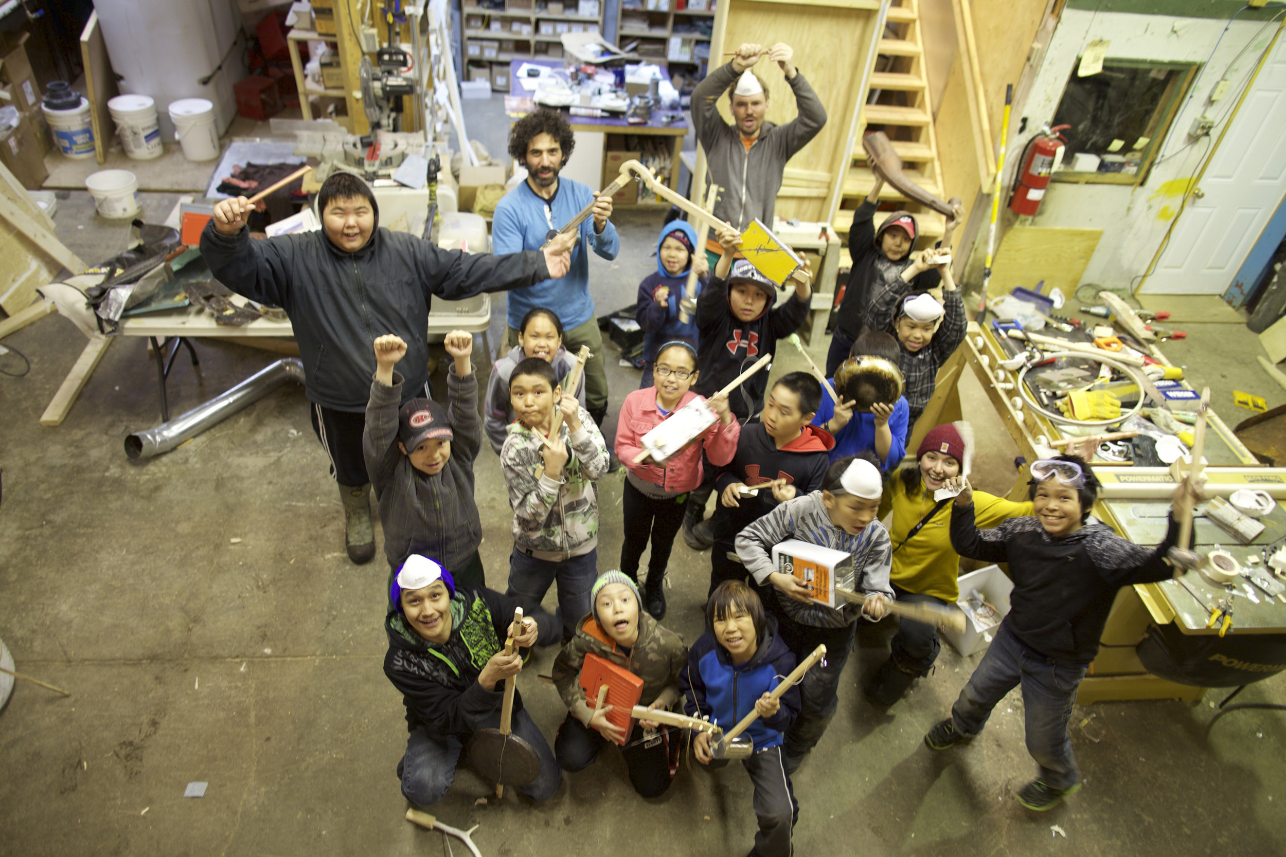 Some of the youth completing their instruments made from found materials in the dump, the burned down high school, and animal bones from the land.