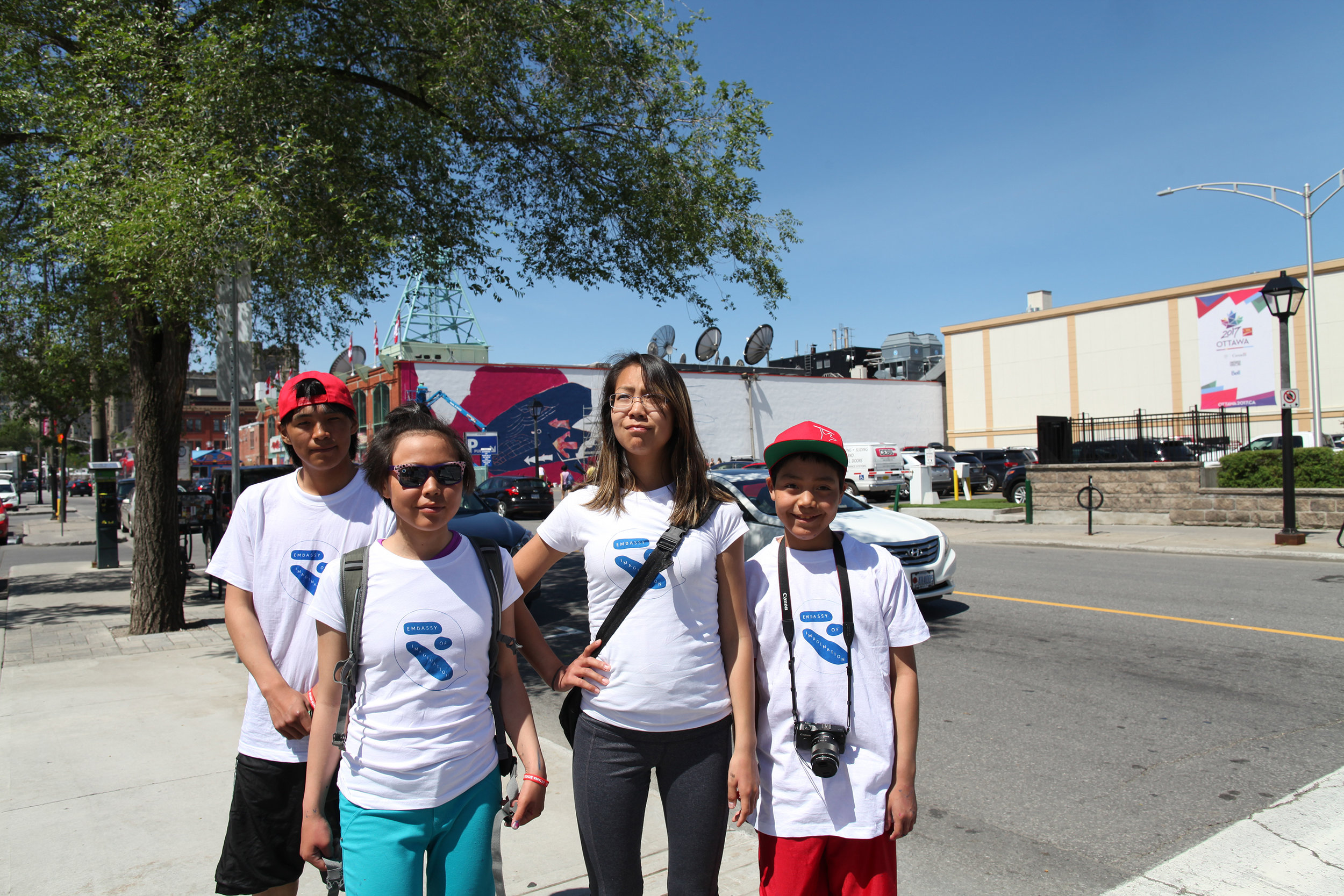 Left to right: Harry Josephee, Christine Adamie, Janice Qimirpik, and Kevin Qimirpik created images for Tunnganarniq. The beginning of the painting behind them!
