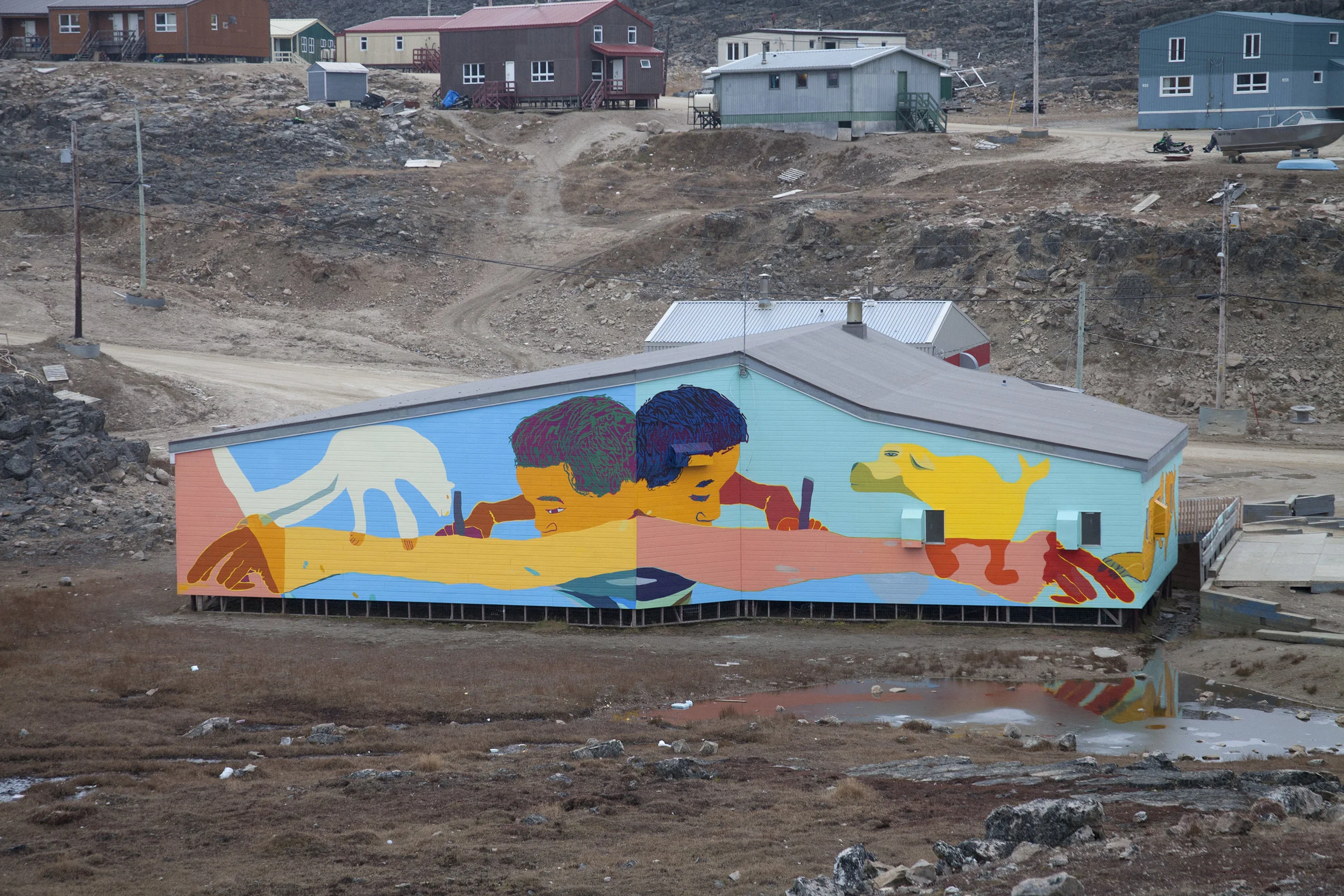 The back wall of the Community Hall. Drawings by Ooloota Quvianaqtuliaq (13), Johnny Samayualie (16), Jolly Saggiatuk (12), and Aggiu Ashevak (13).