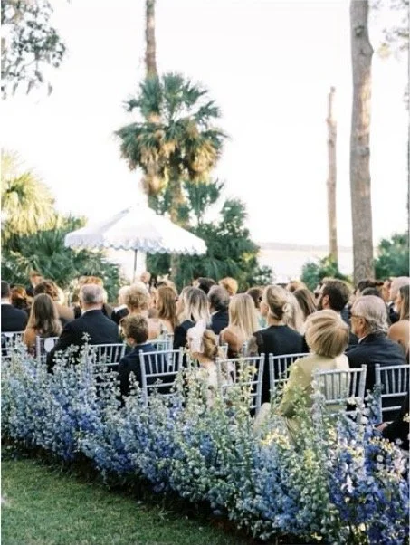 wedding guests seated outdoors waiting for the wedding ceremony to start