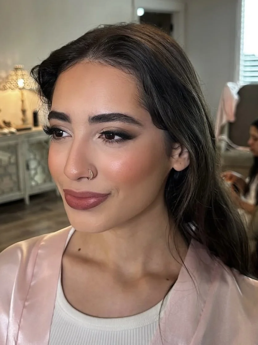 close up picture of a bride wearing glam wedding makeup with a pop of color on the cheeks and lips