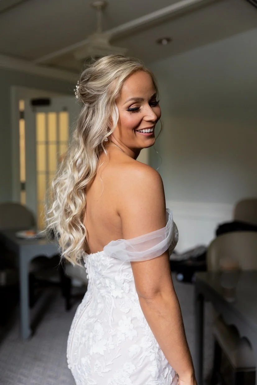 professional photography picture of a bride in her wedding gown showing off a half up hairstyle and soft glam makeup