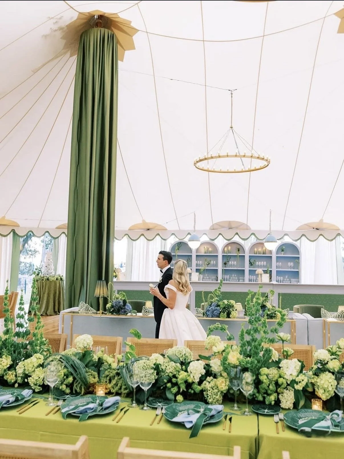bride and groom walking under their reception tent