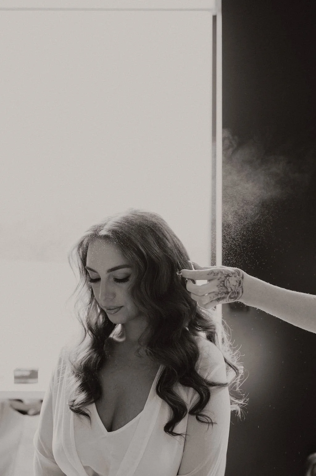 stylist finishing hair style with spray