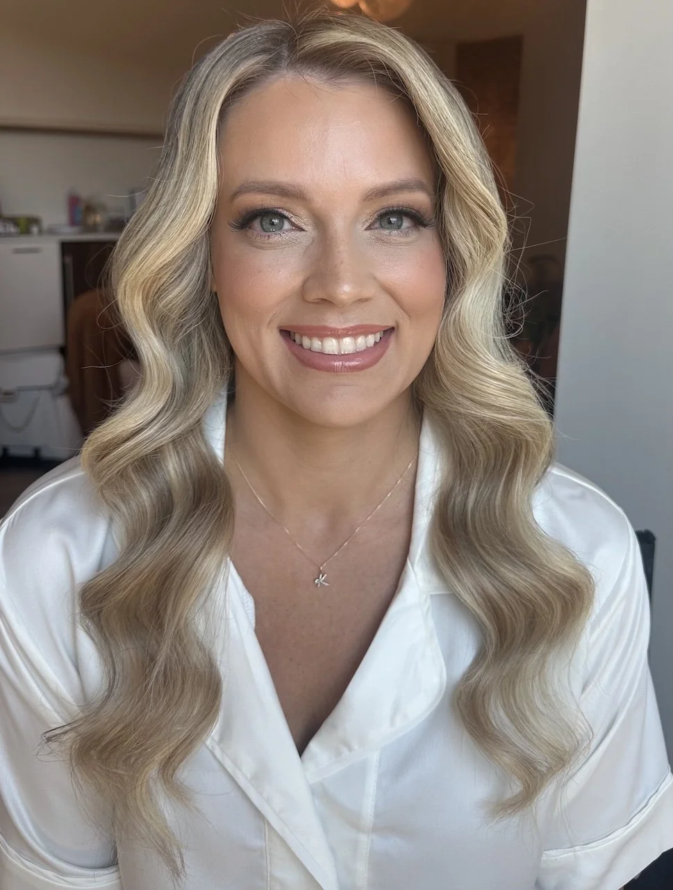 bride with blonde hair and blue eyes wearing airbrush makeup on her wedding day