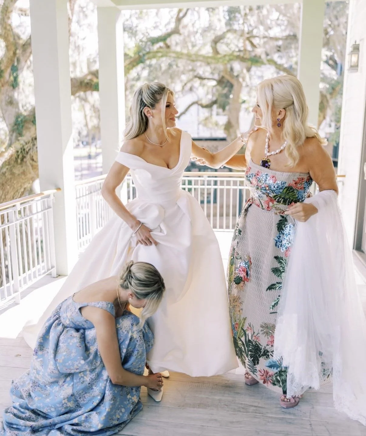 bride slips on her shoes on the front porch after getting her wedding dress on